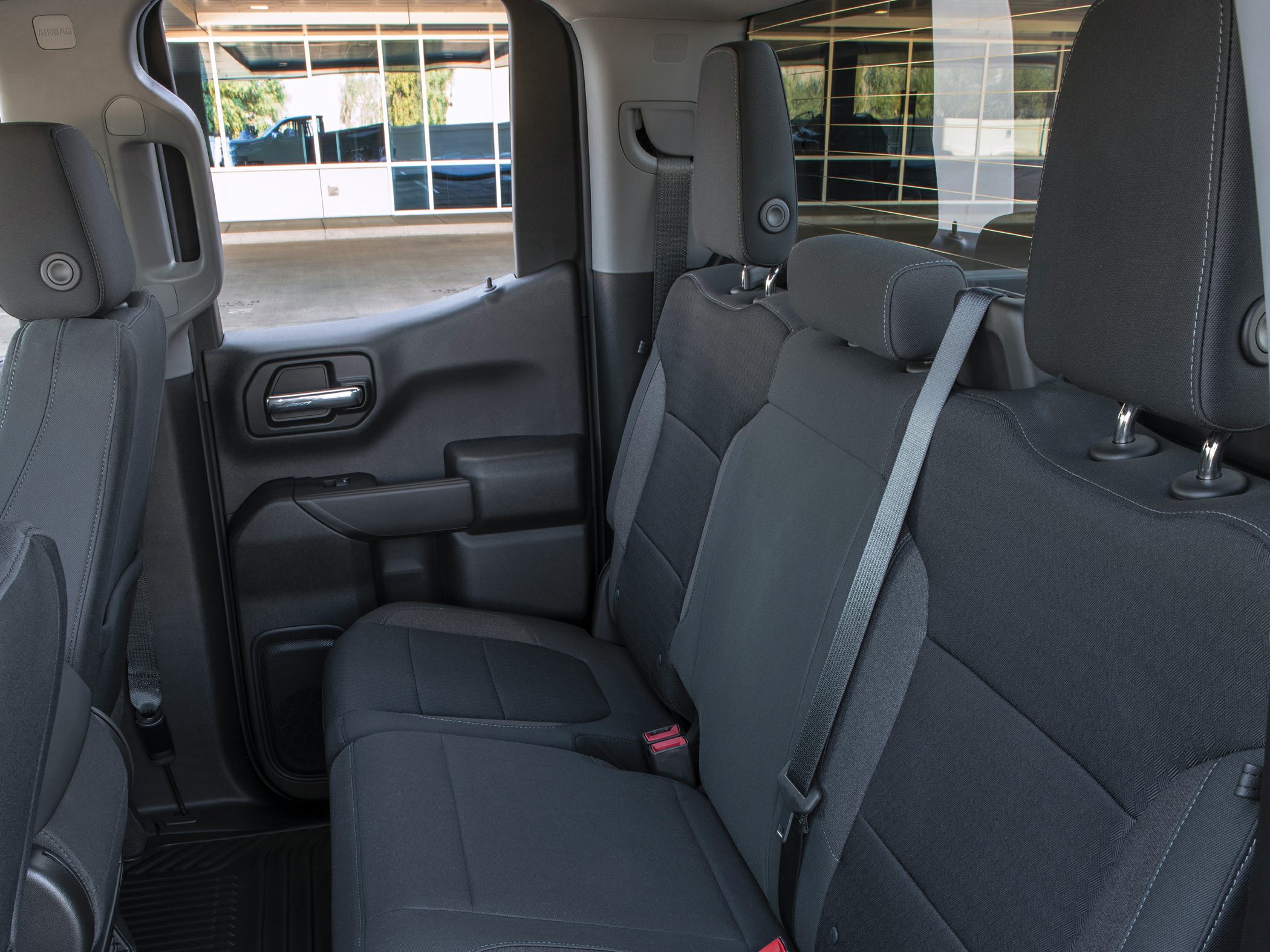 Rear seat interior with black upholstery and seatbelt of a pickup truck