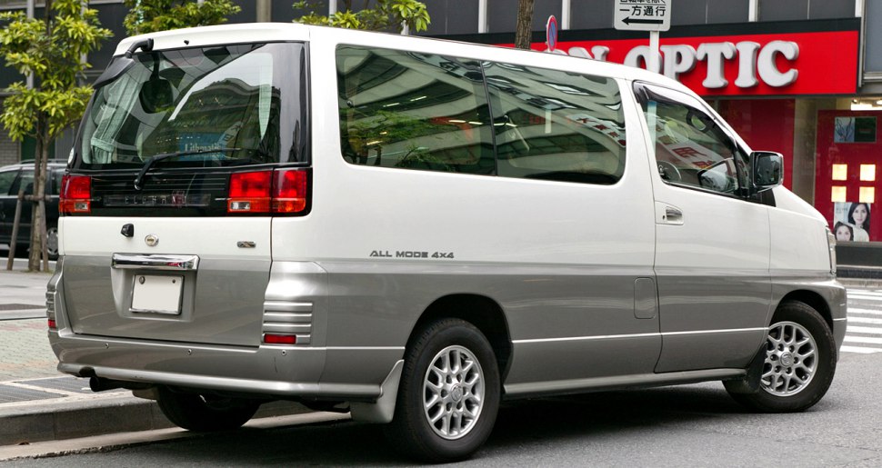 Rear and side view of a boxy, dual-tone minivan with large windows and 4x4 badge.