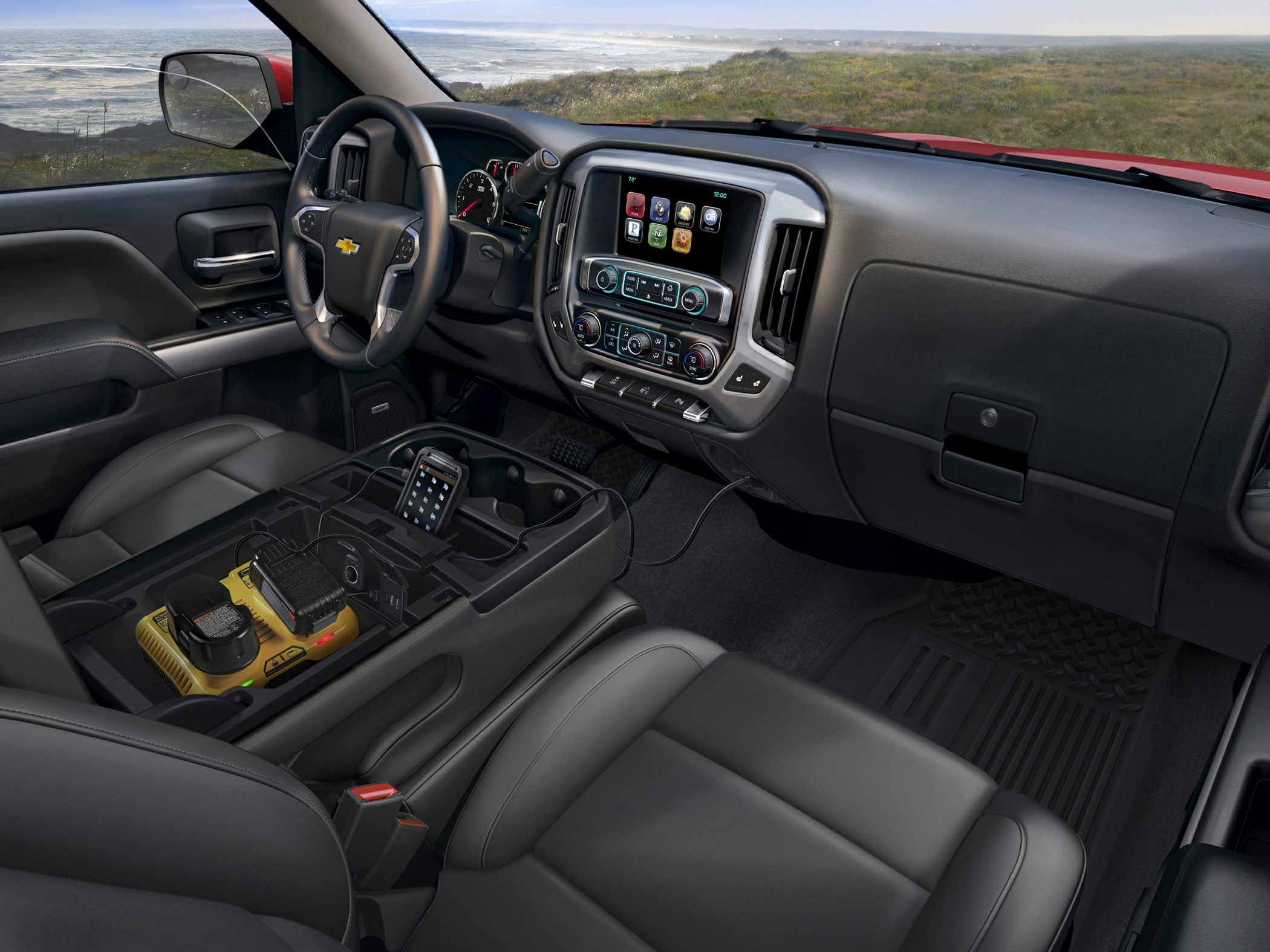 Truck interior with infotainment system, leather seating, and large center console with charger.