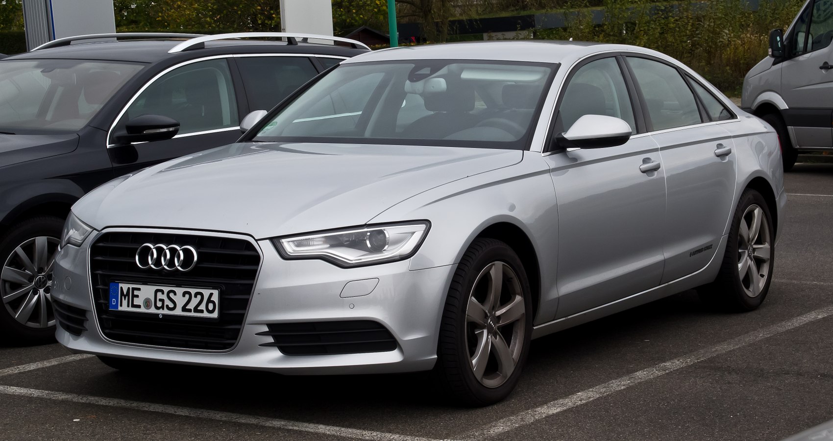 Silver sedan front three-quarter view with alloy wheels and prominent grille