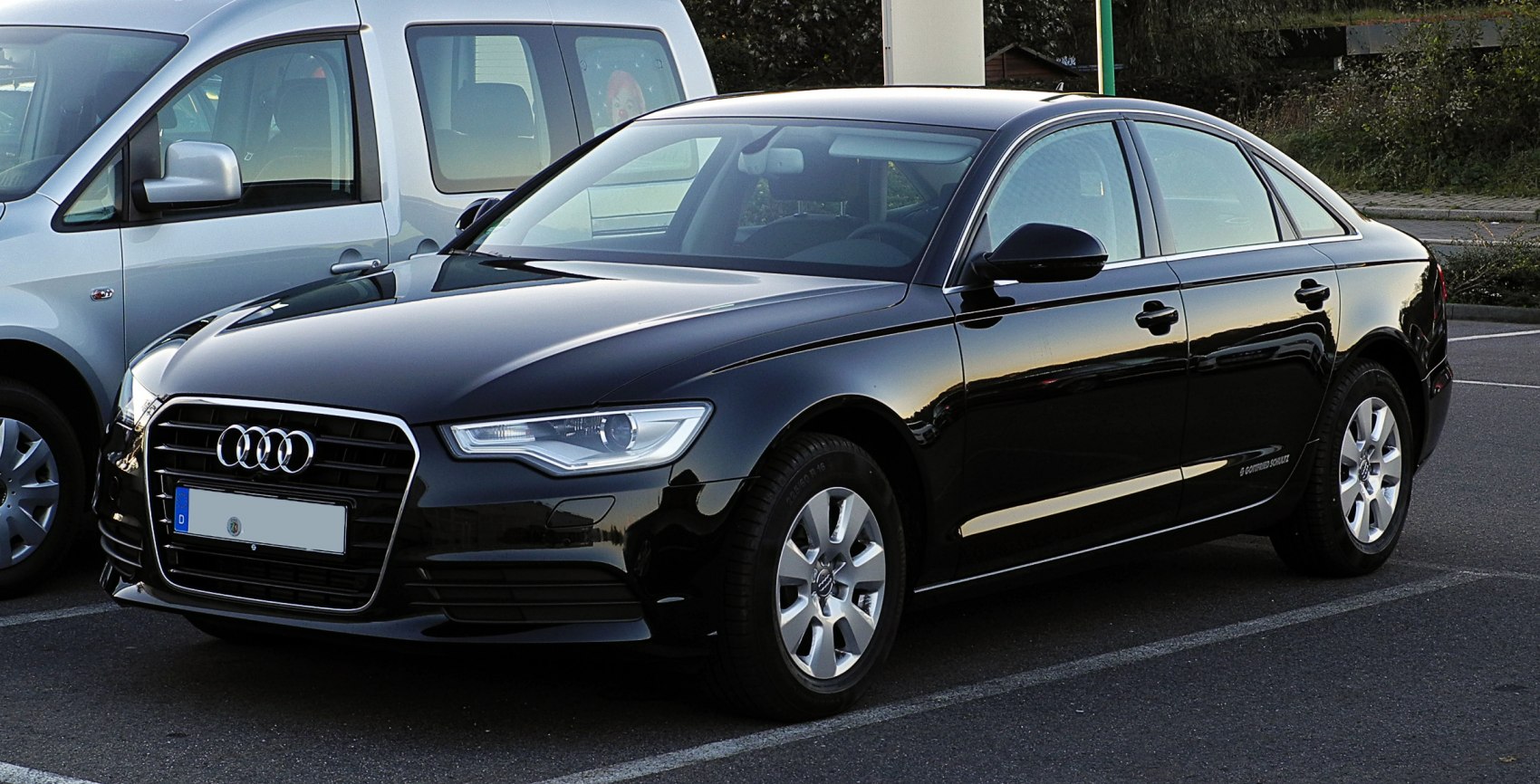 Front side view of black luxury sedan with LED headlights and alloy wheels