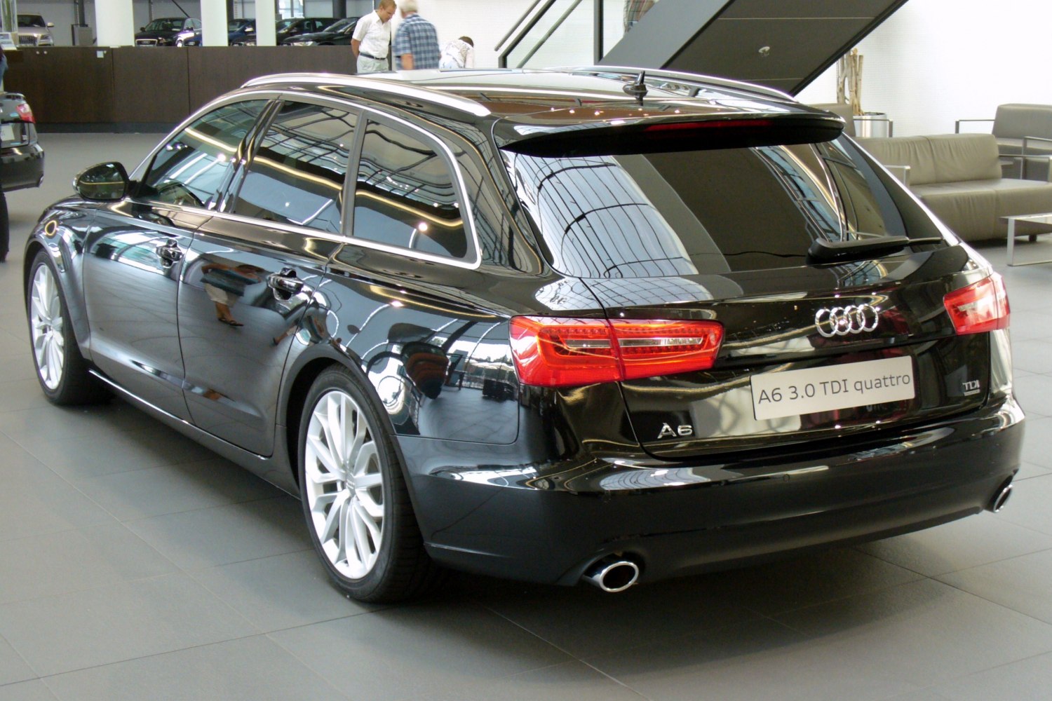 Rear and side profile of a luxury station wagon with LED taillights and dual exhaust.