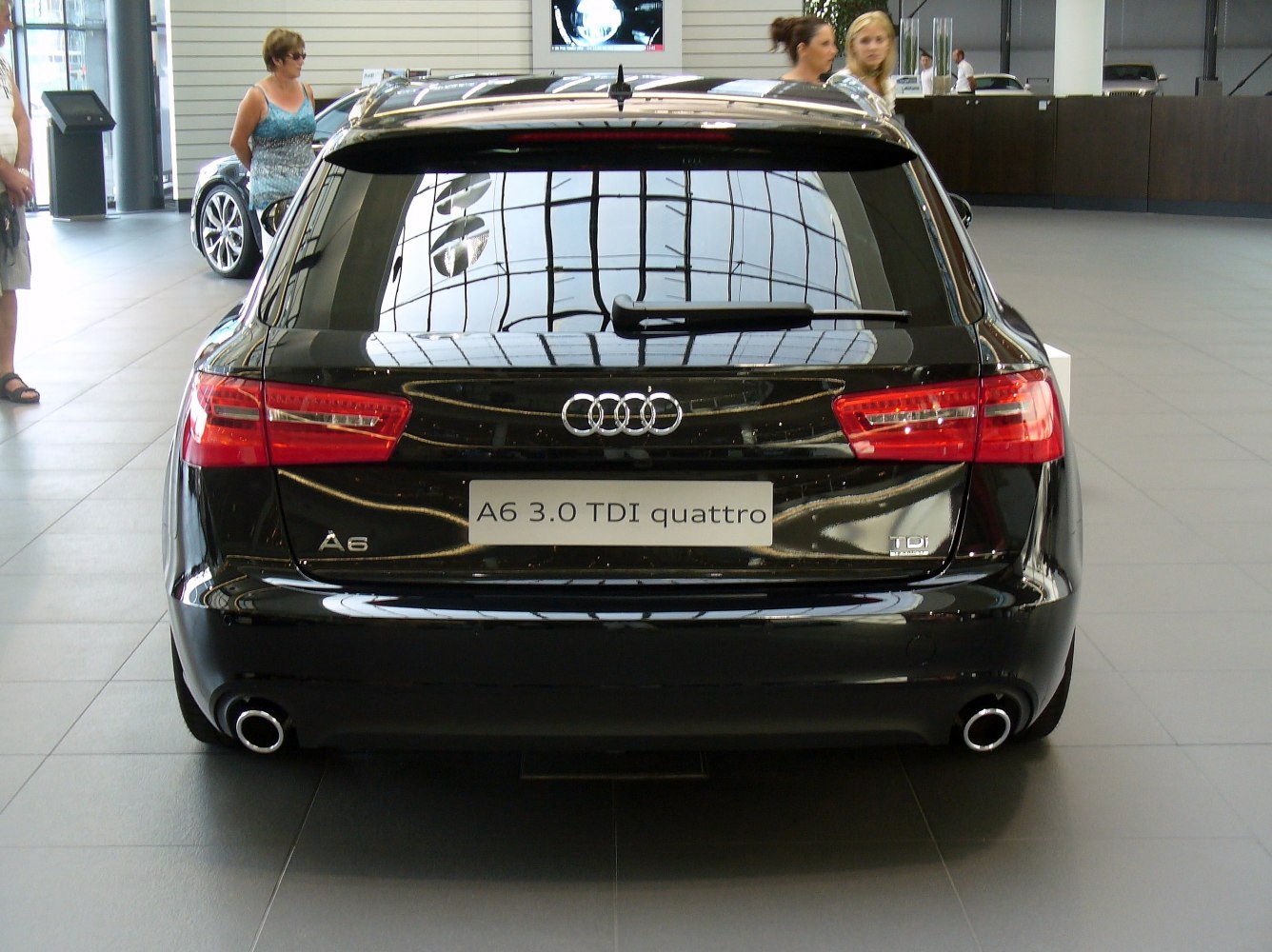 Rear view of black station wagon with taillights and dual exhaust pipes
