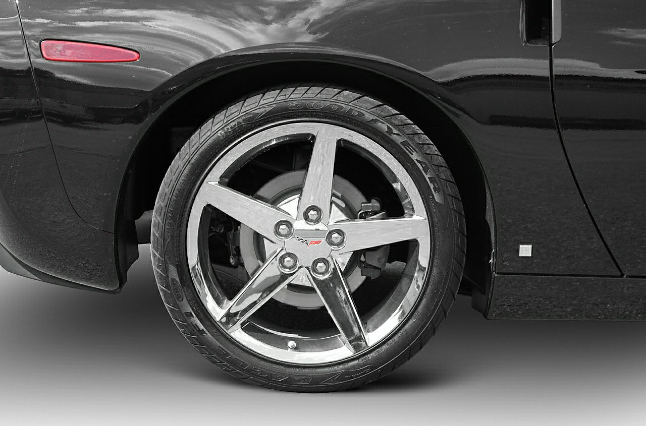Chrome five-spoke alloy wheel and tire with brake disc on black car body