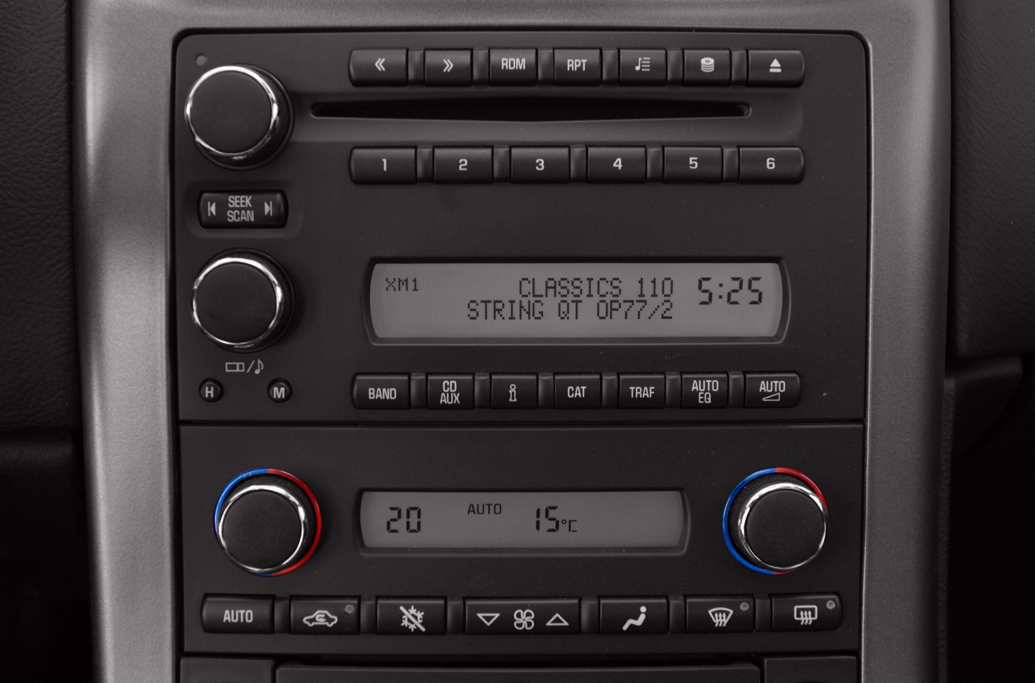 Car stereo system and dual-zone climate control panel with knobs and buttons.