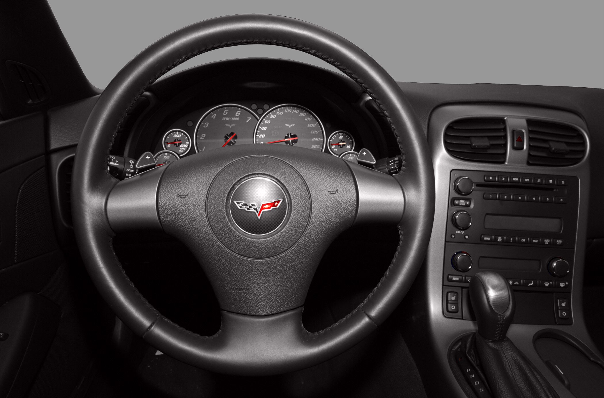 Steering wheel with Corvette emblem and analog dashboard gauges