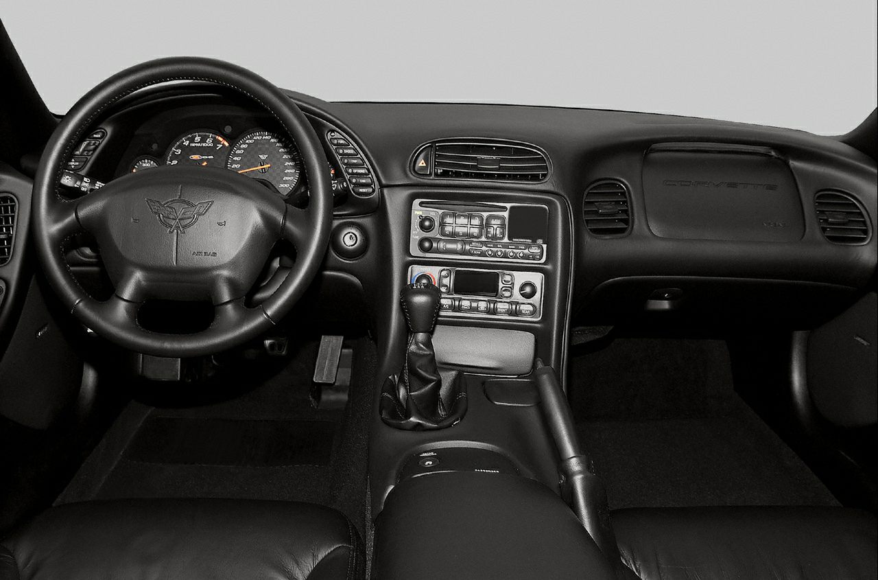 Interior with dashboard, steering wheel, manual gearshift, and center console