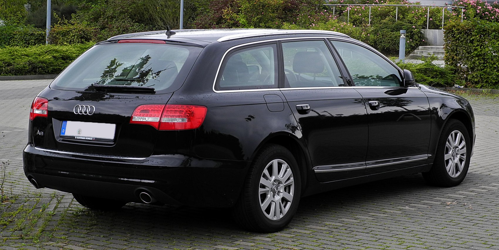 Rear and side view of black station wagon with dual exhaust and roof rails