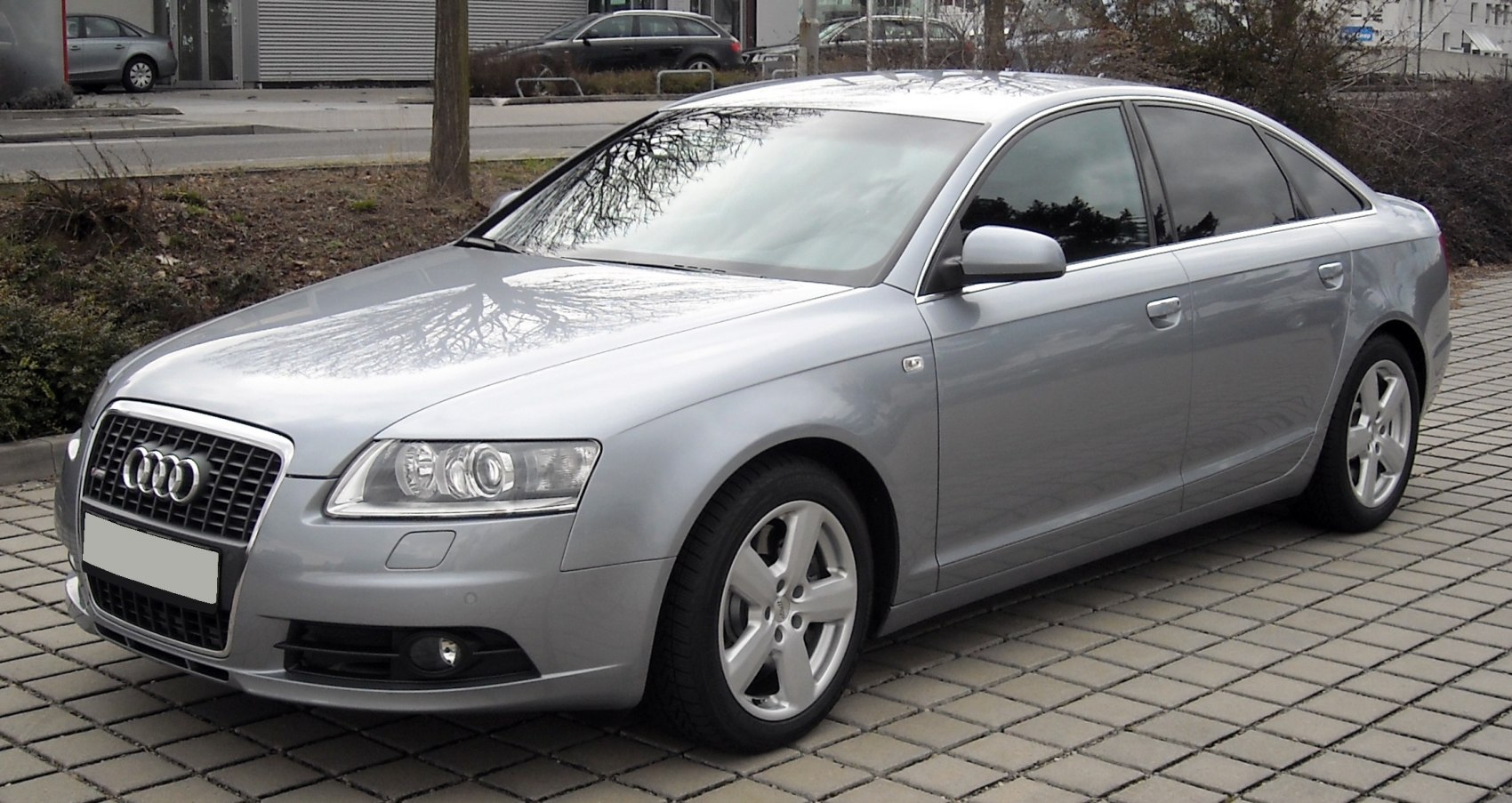 Silver sedan front-side view with prominent headlights and grille