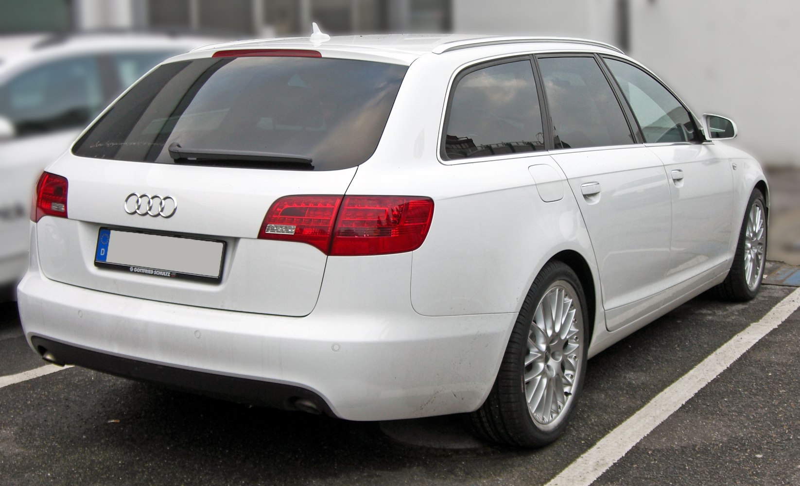 Rear view of white estate car with distinctive tail lights and alloy wheels