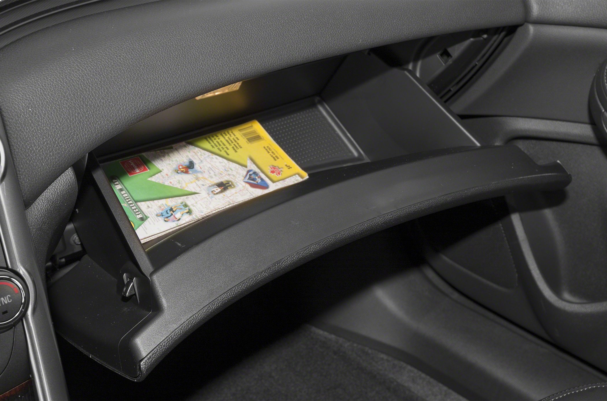 Open glove box with map inside in car interior