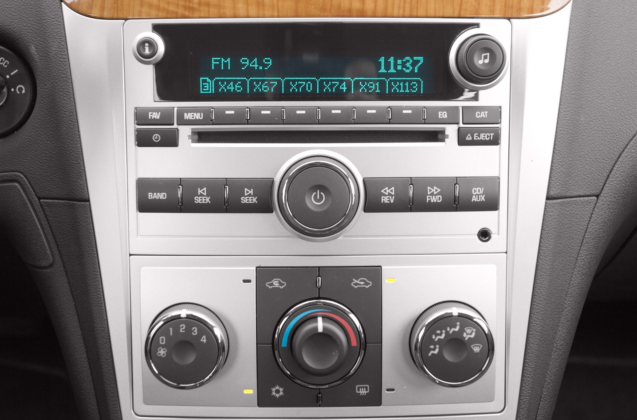 Close-up of audio system and manual climate control knobs.