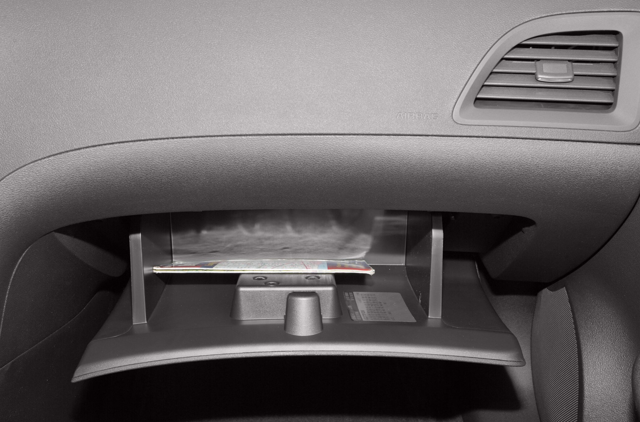 Glove compartment open with dashboard air vent and storage detail