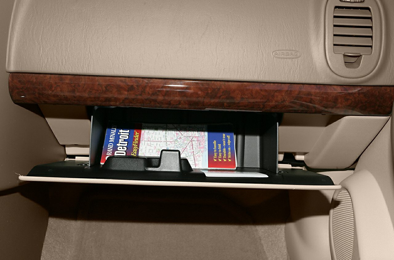 Open glove compartment with map and wood dashboard trim