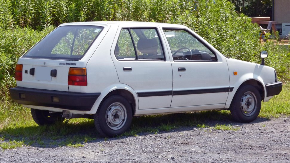 White compact hatchback with rear side view and angular design