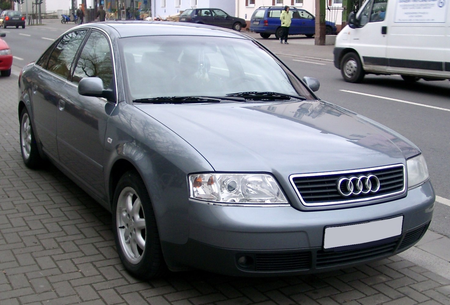 Silver sedan front view showing headlight, grille, and wheel.