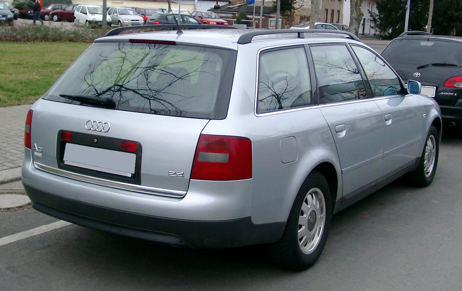 Rear and side exterior view of silver station wagon with roof rails