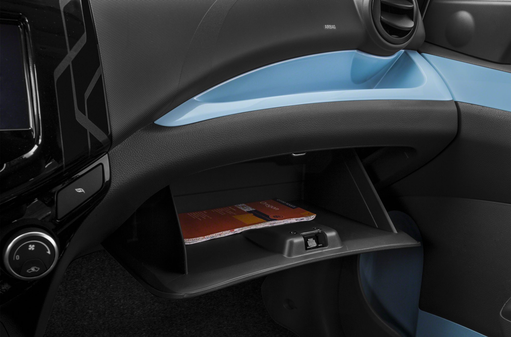 Open glove compartment with visible storage and dashboard trim