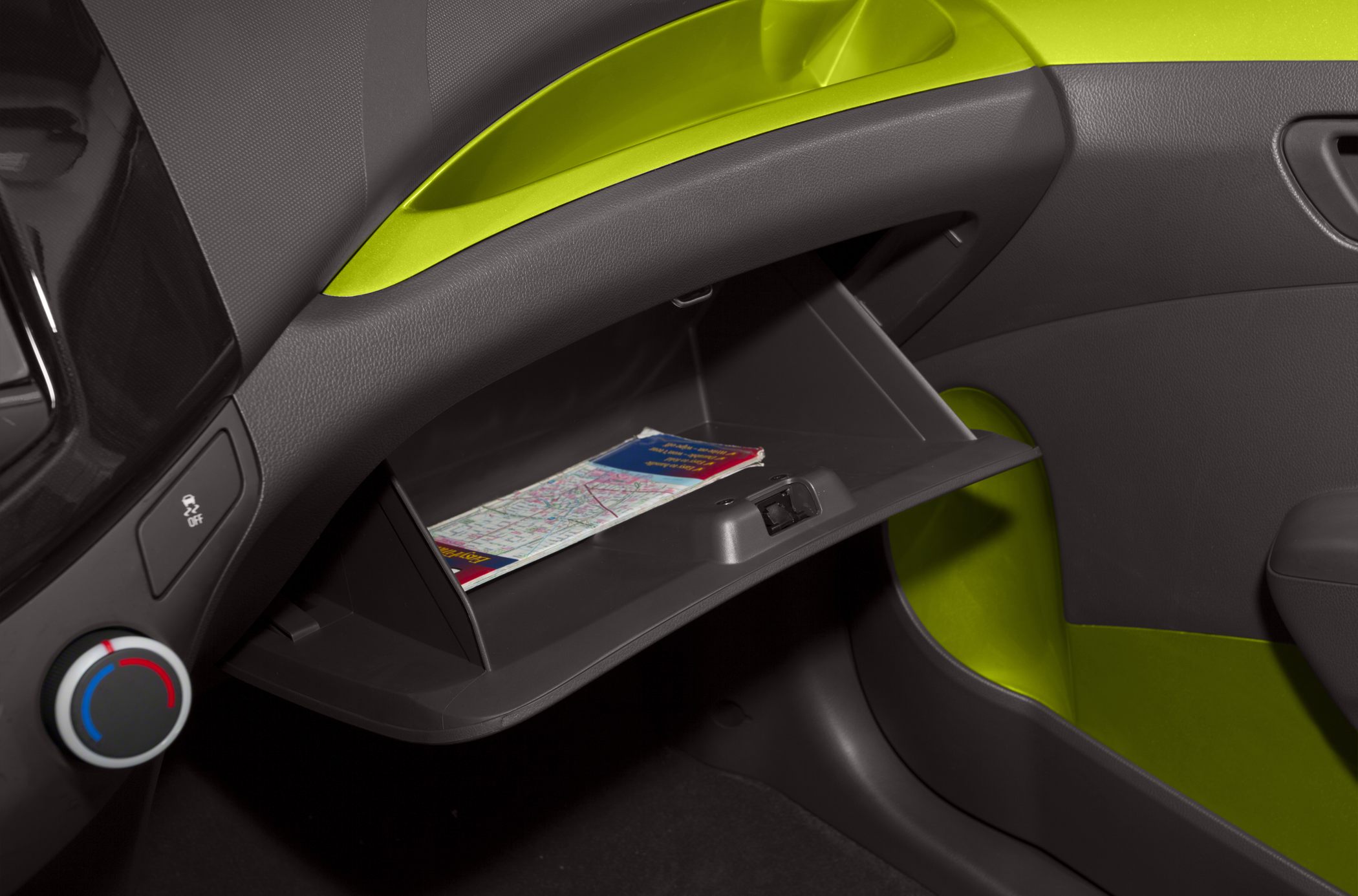 Open glove compartment with climate control dial and dashboard section.