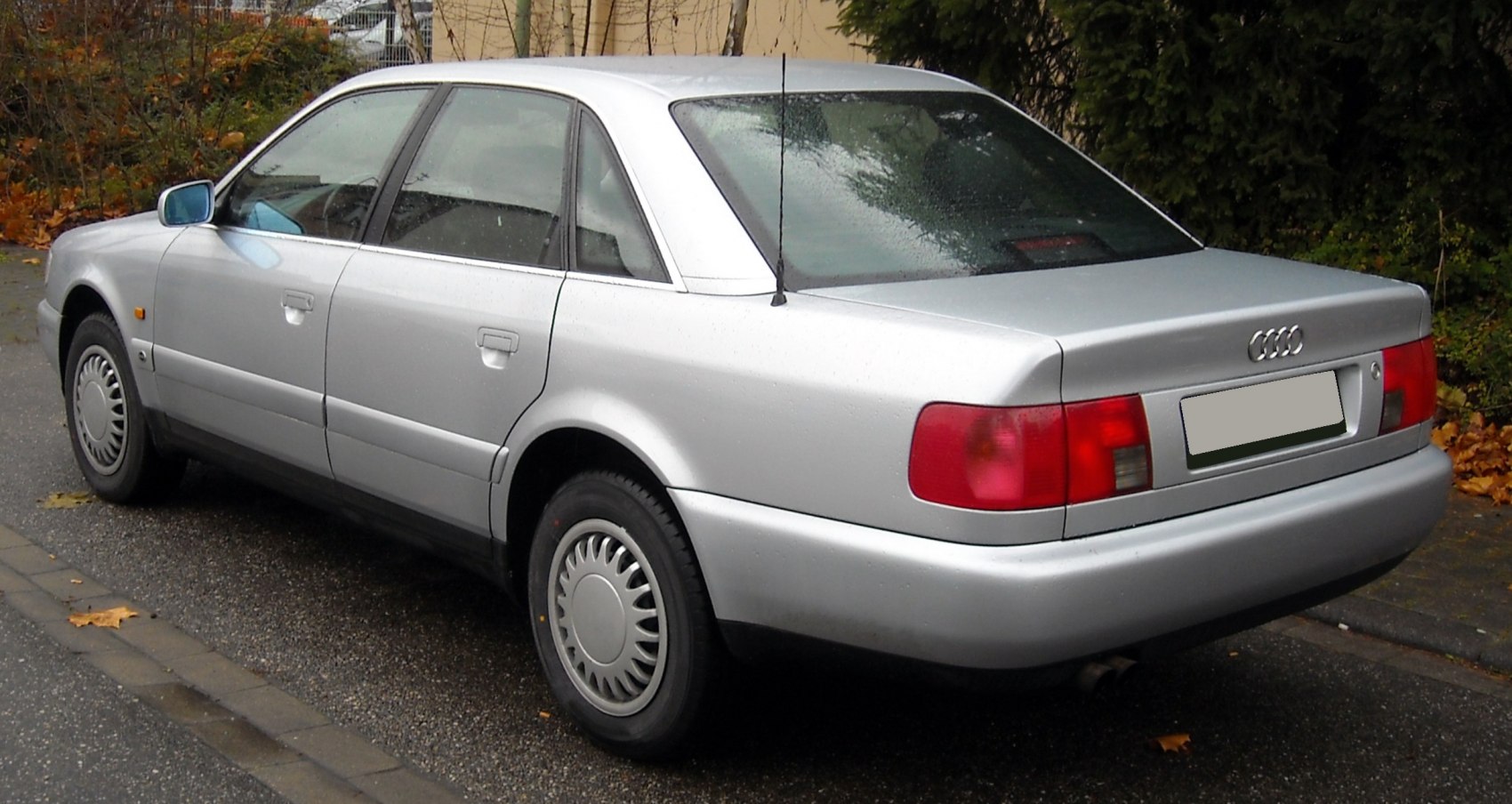 rear side view of silver classic sedan with wheel hubcaps