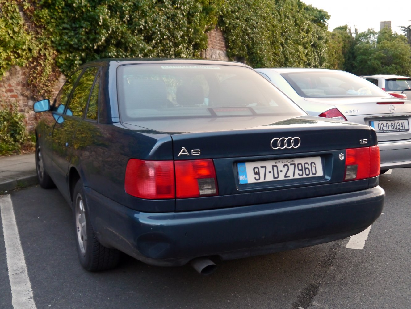 Rear view of mid-90s sedan with classic rectangular taillights and distinct trunk design
