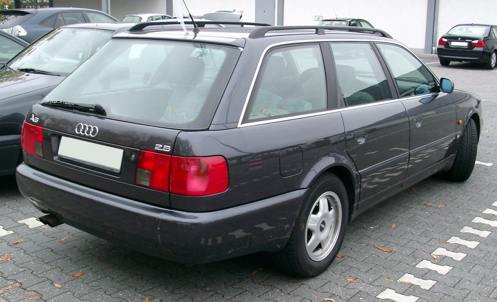 Rear-side view of a station wagon with roof rails and alloy wheels