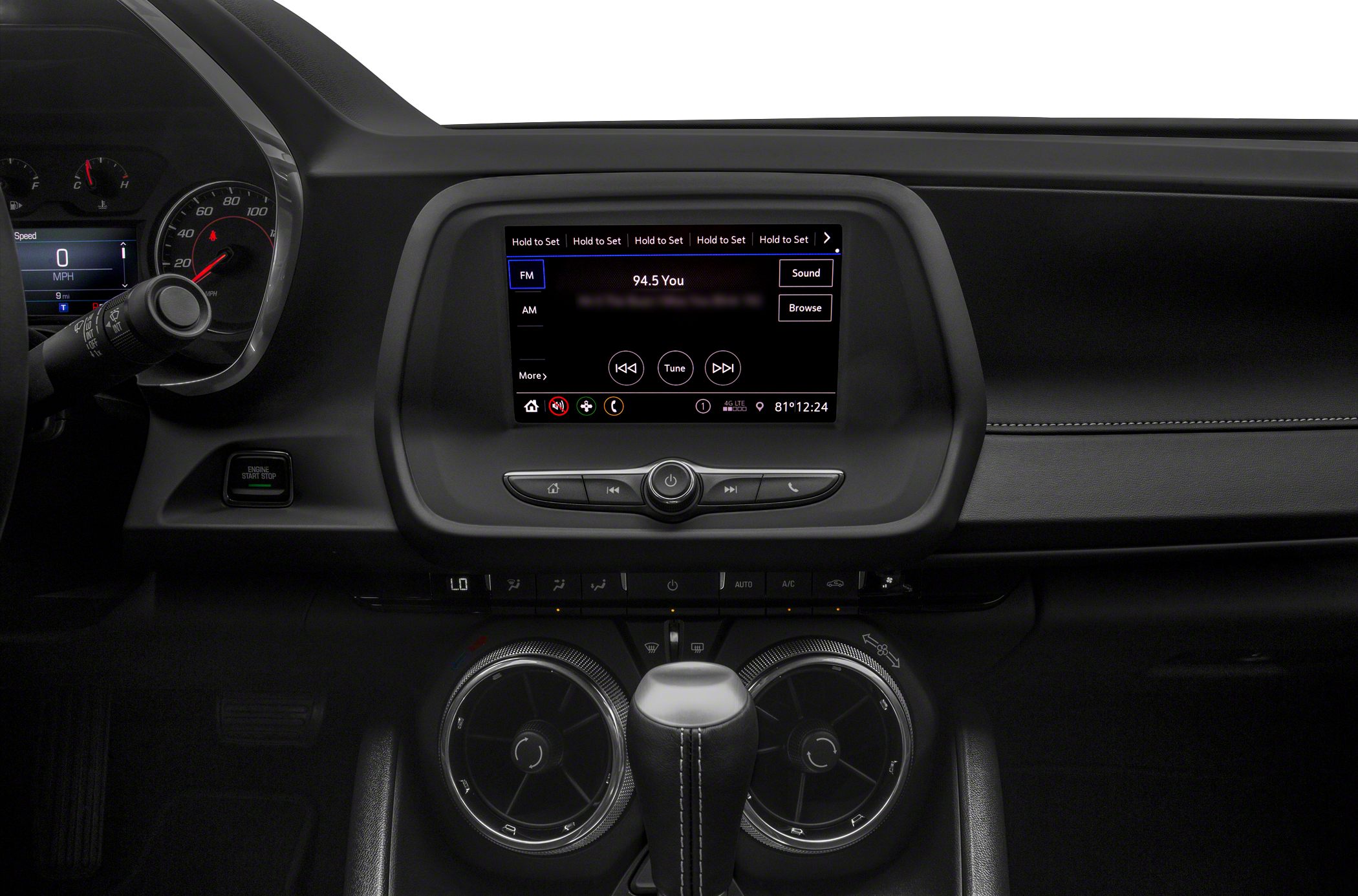 Dashboard with digital display, air vents, and gear shift.