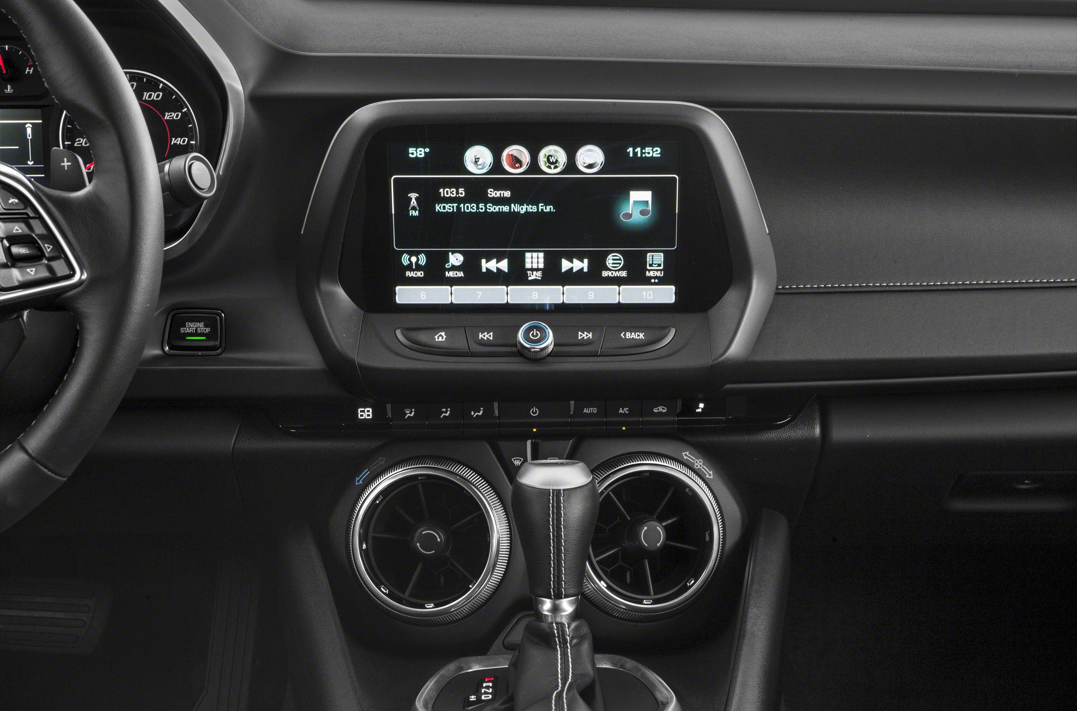 Infotainment touchscreen, circular air vents, and gear shifter with start stop button