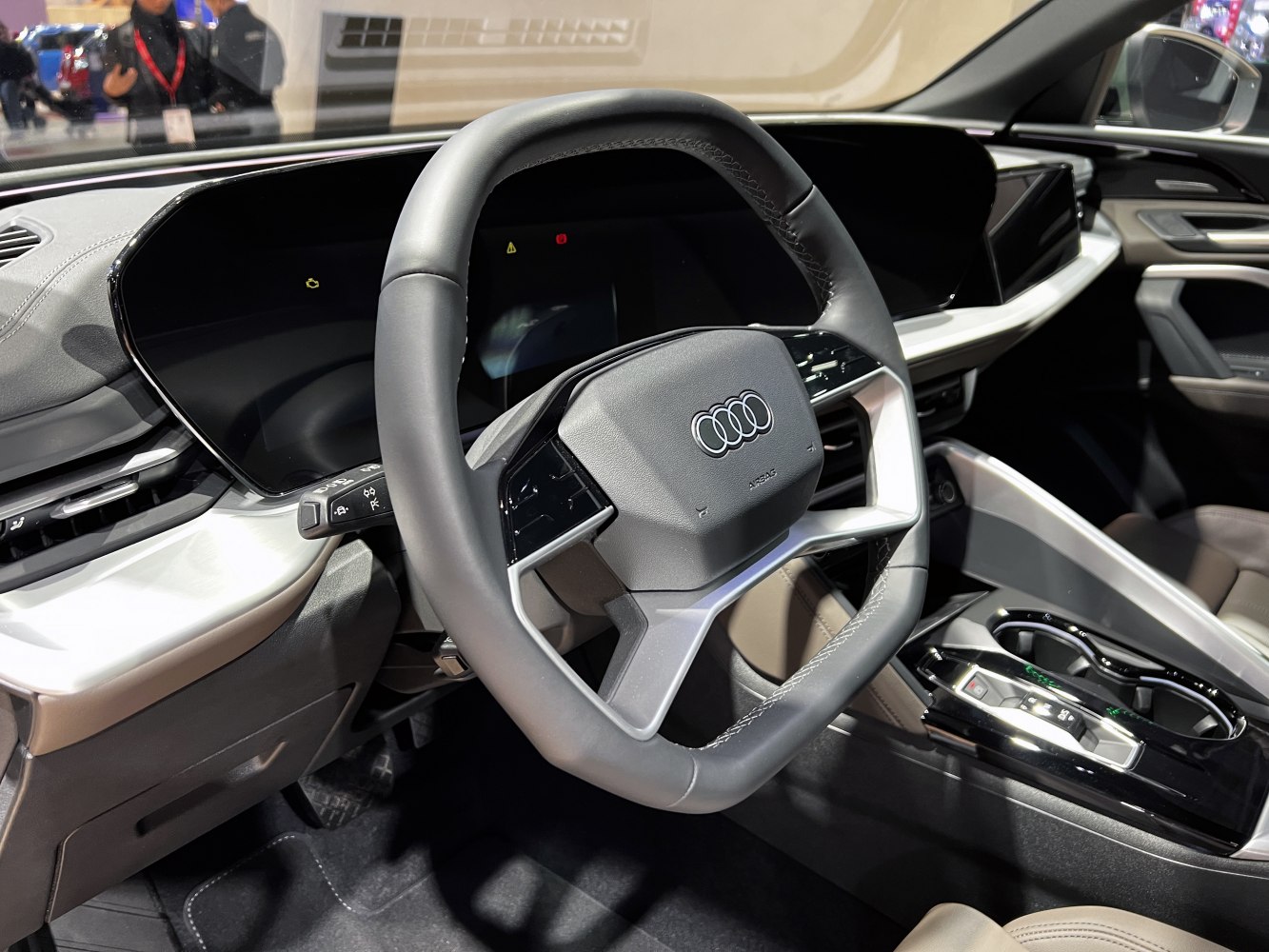 Modern steering wheel and large digital dashboard with center console.