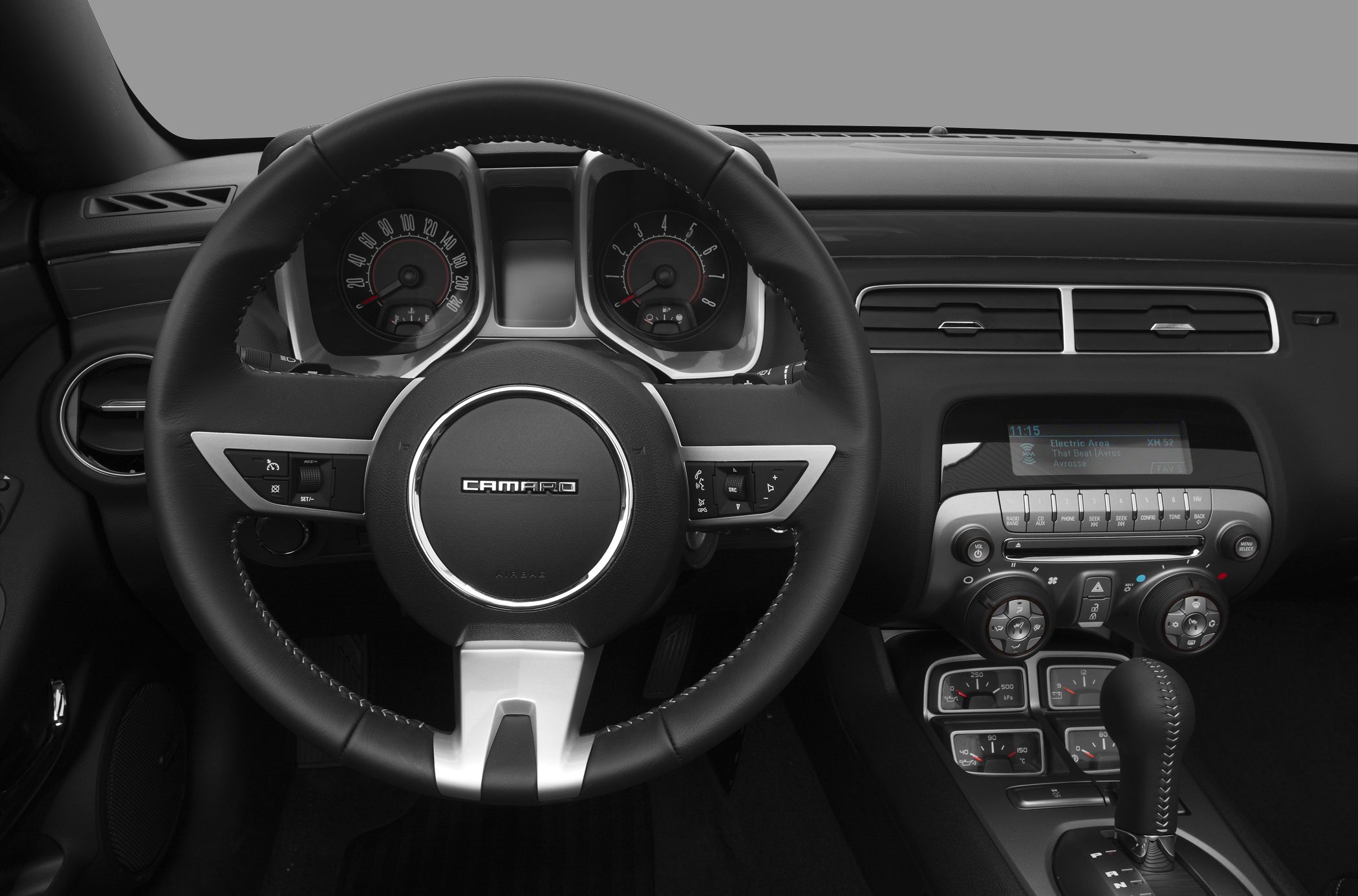 Steering wheel, round gauges, and center console controls in car interior