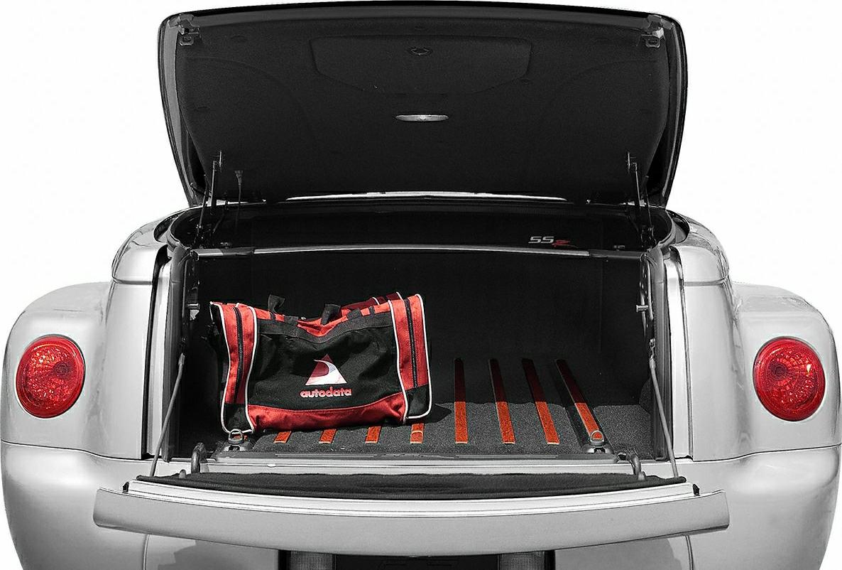 Open rear trunk with red-accented black lining and a duffel bag