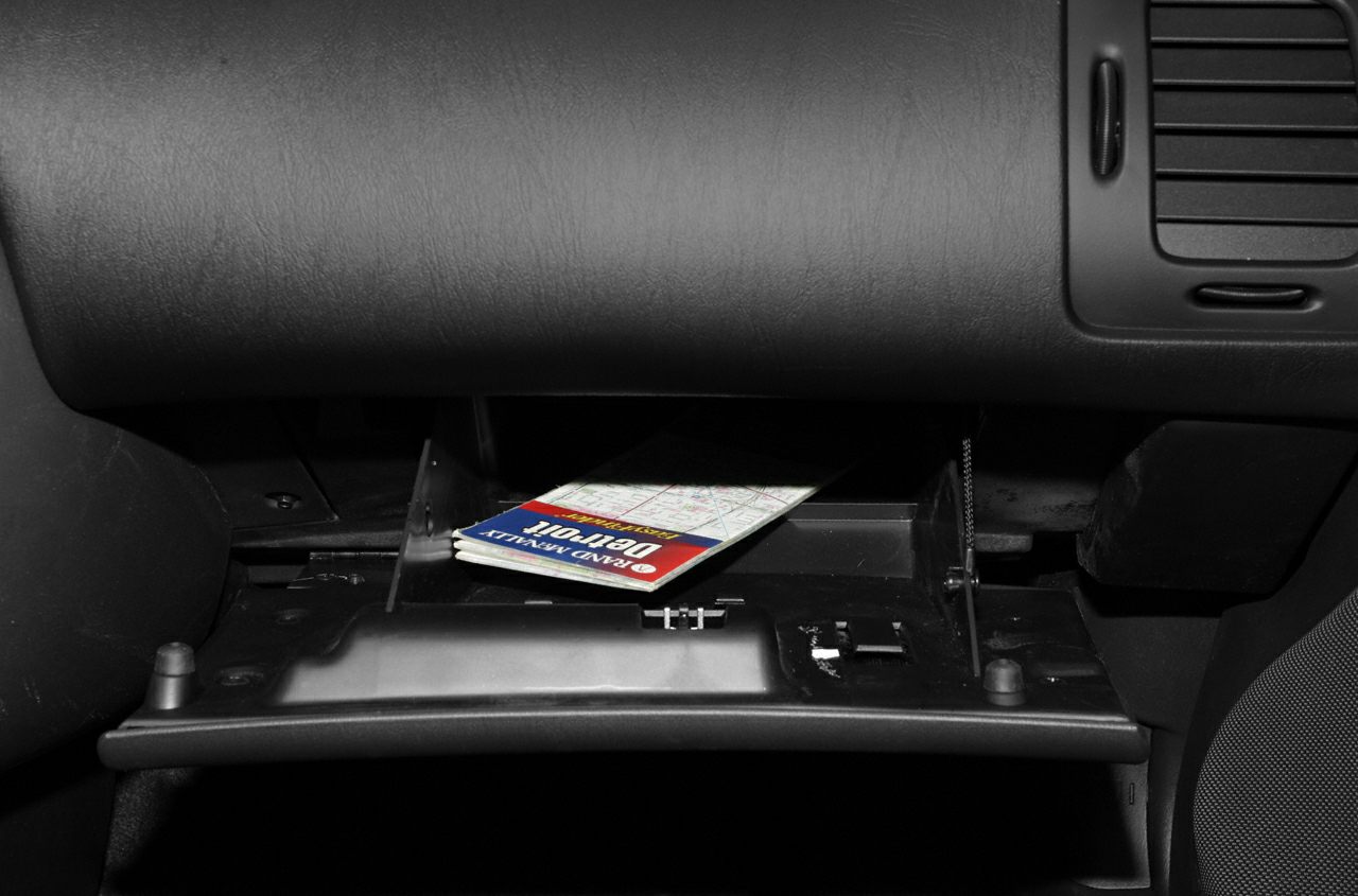 Open glove compartment with map inside car interior