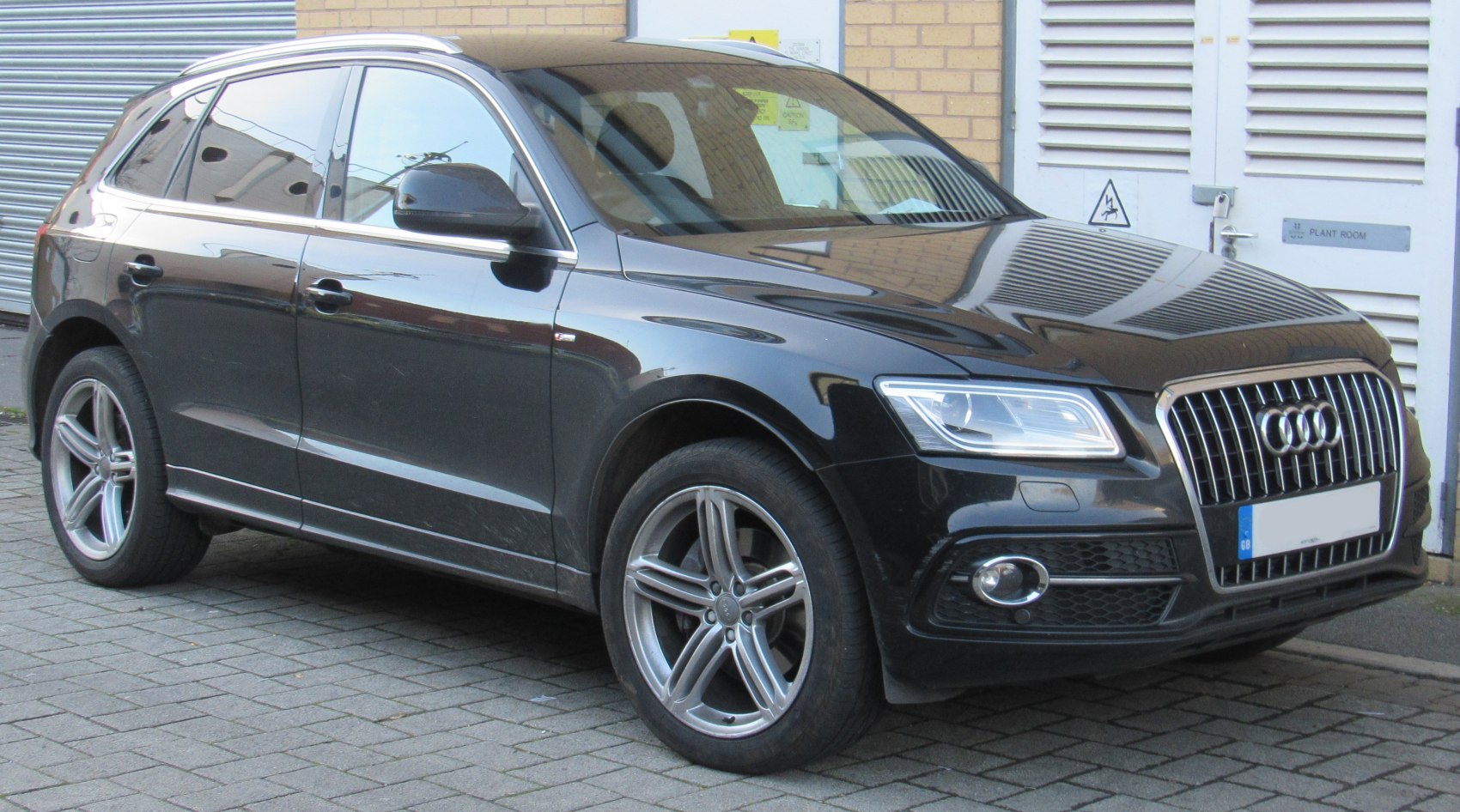 Front-side view of black luxury SUV with distinctive grille and alloy wheels
