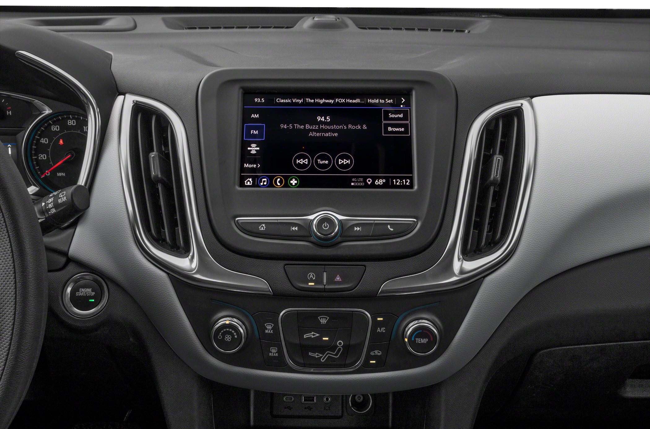 Touchscreen infotainment system with surrounding climate control knobs and buttons.