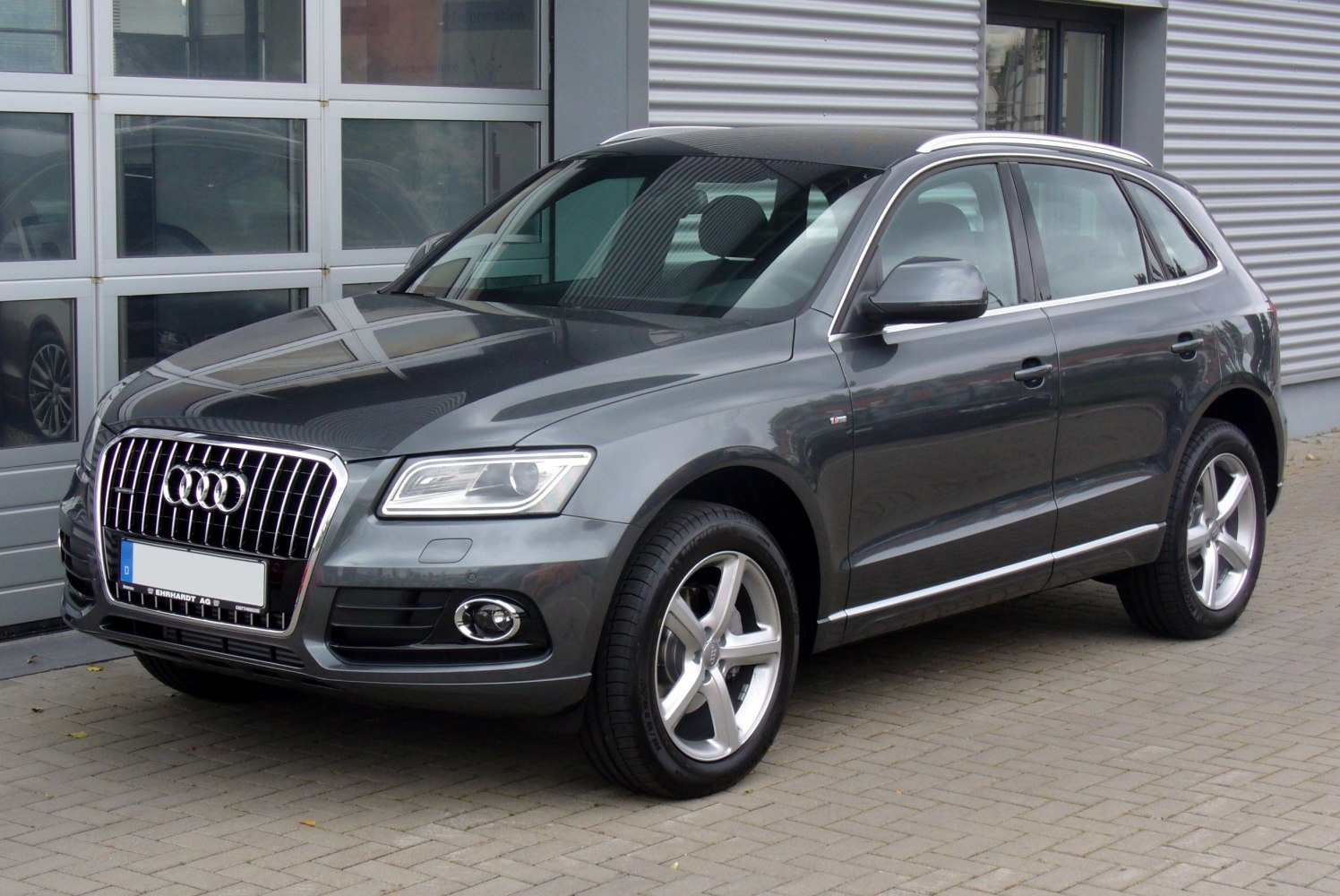 Front side view of SUV with distinctive grille and alloy wheels.