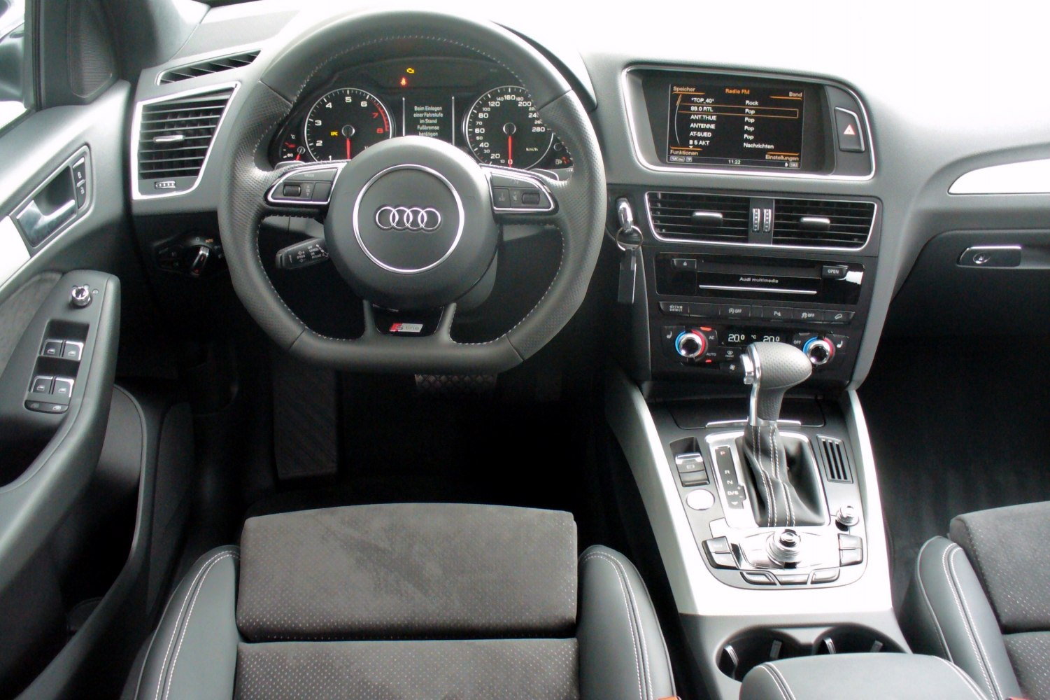 Audi SUV interior with dashboard, steering wheel, and multimedia display