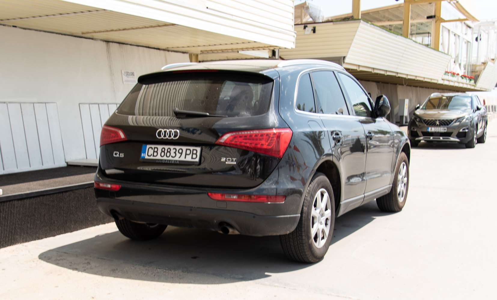 Rear angle view of black mid-size SUV with 2.0T badge and rear lights