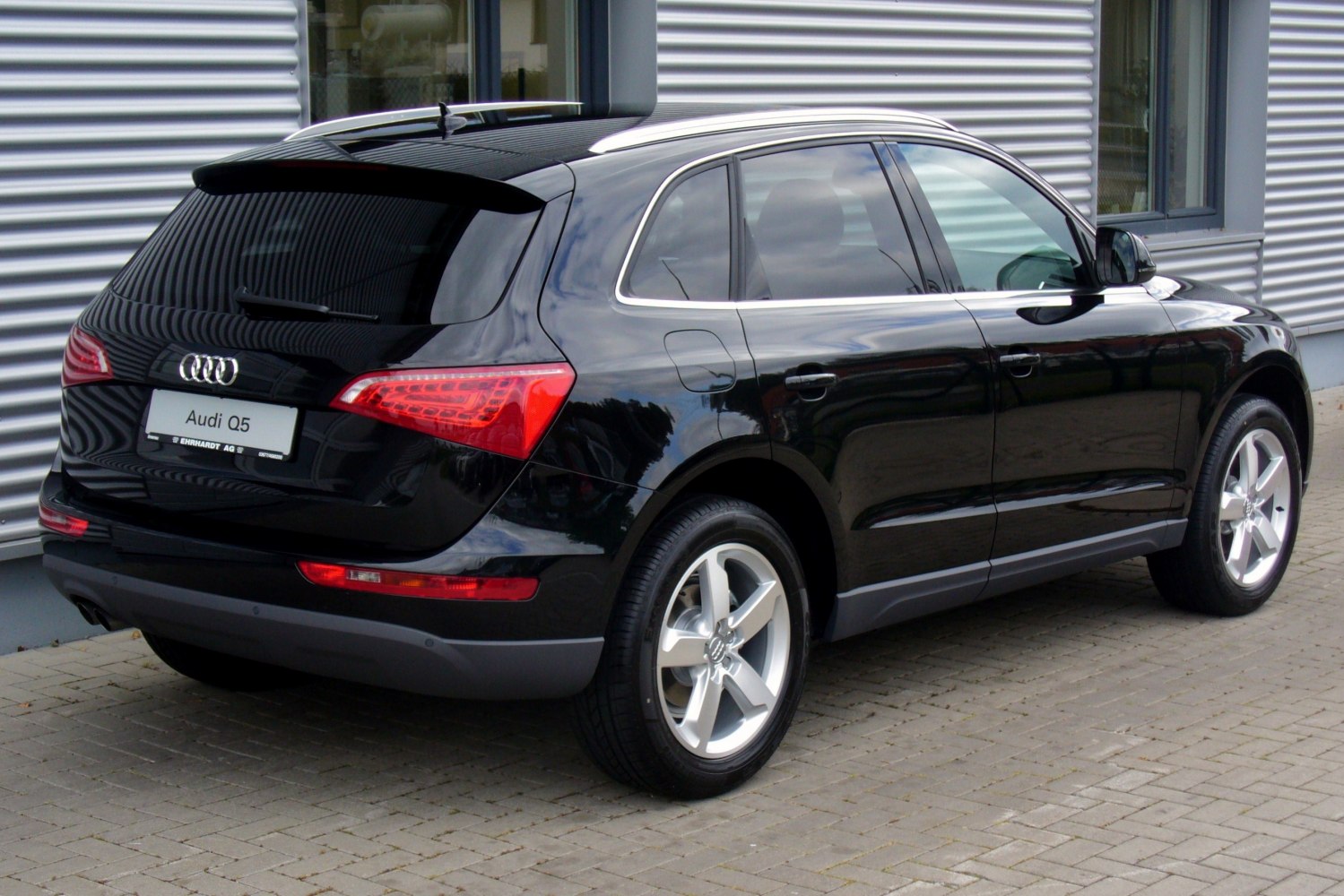 Rear and side profile of a black SUV with distinct taillights and alloy wheels