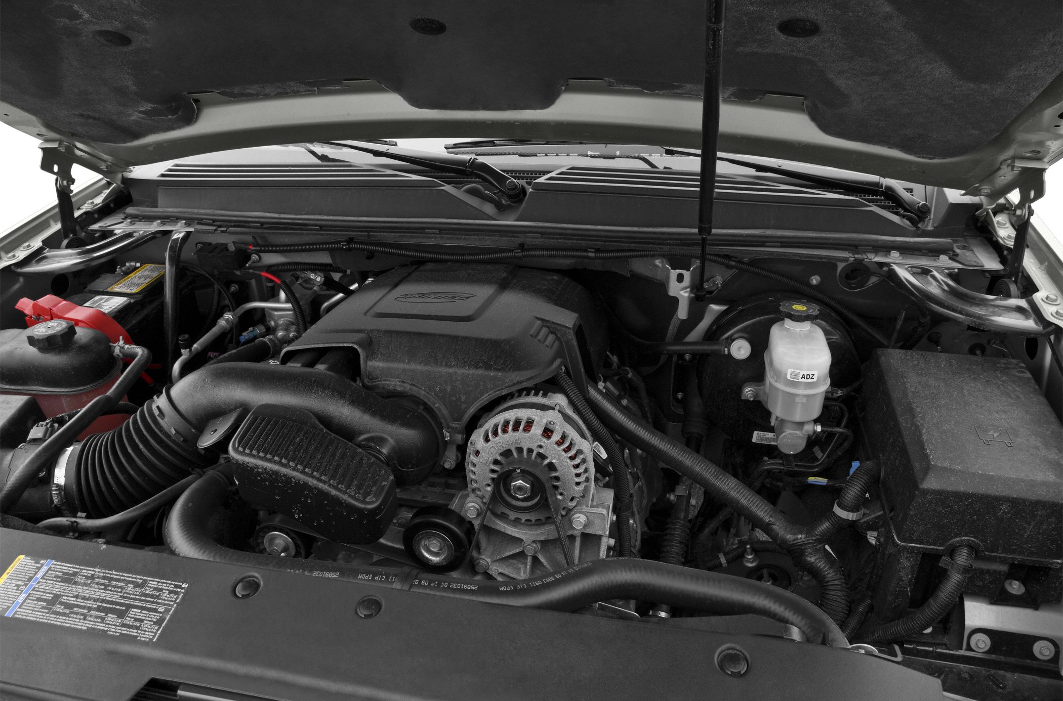 Close-up of engine bay with alternator, air intake, and fluid reservoir.