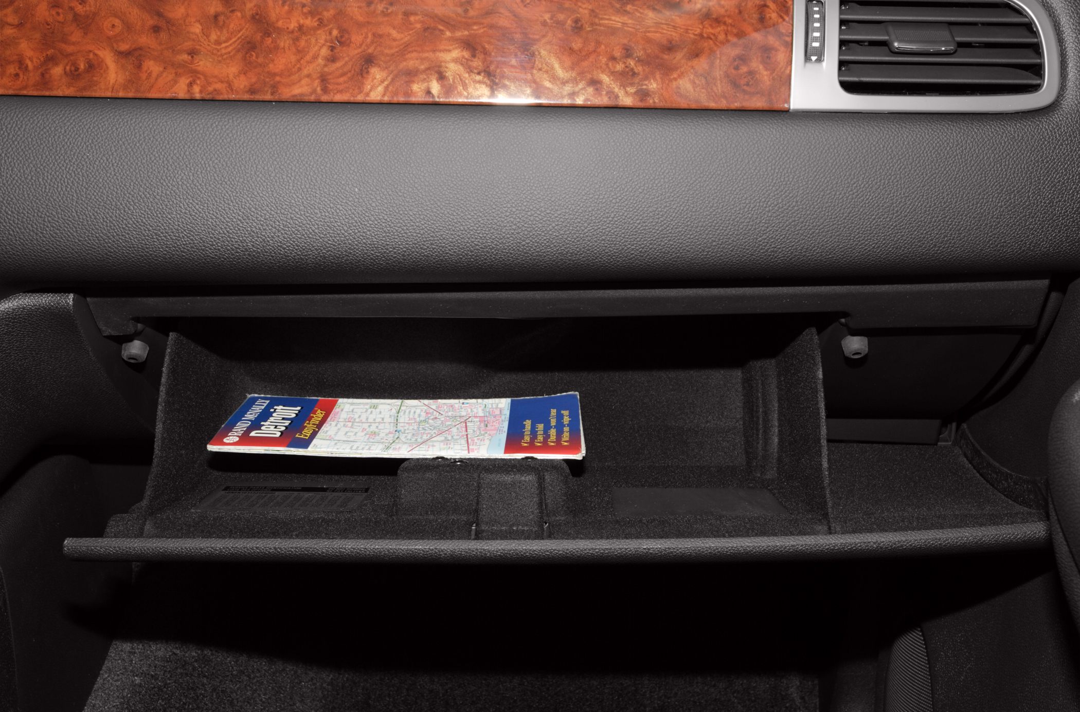 Open glove compartment with map on interior dashboard