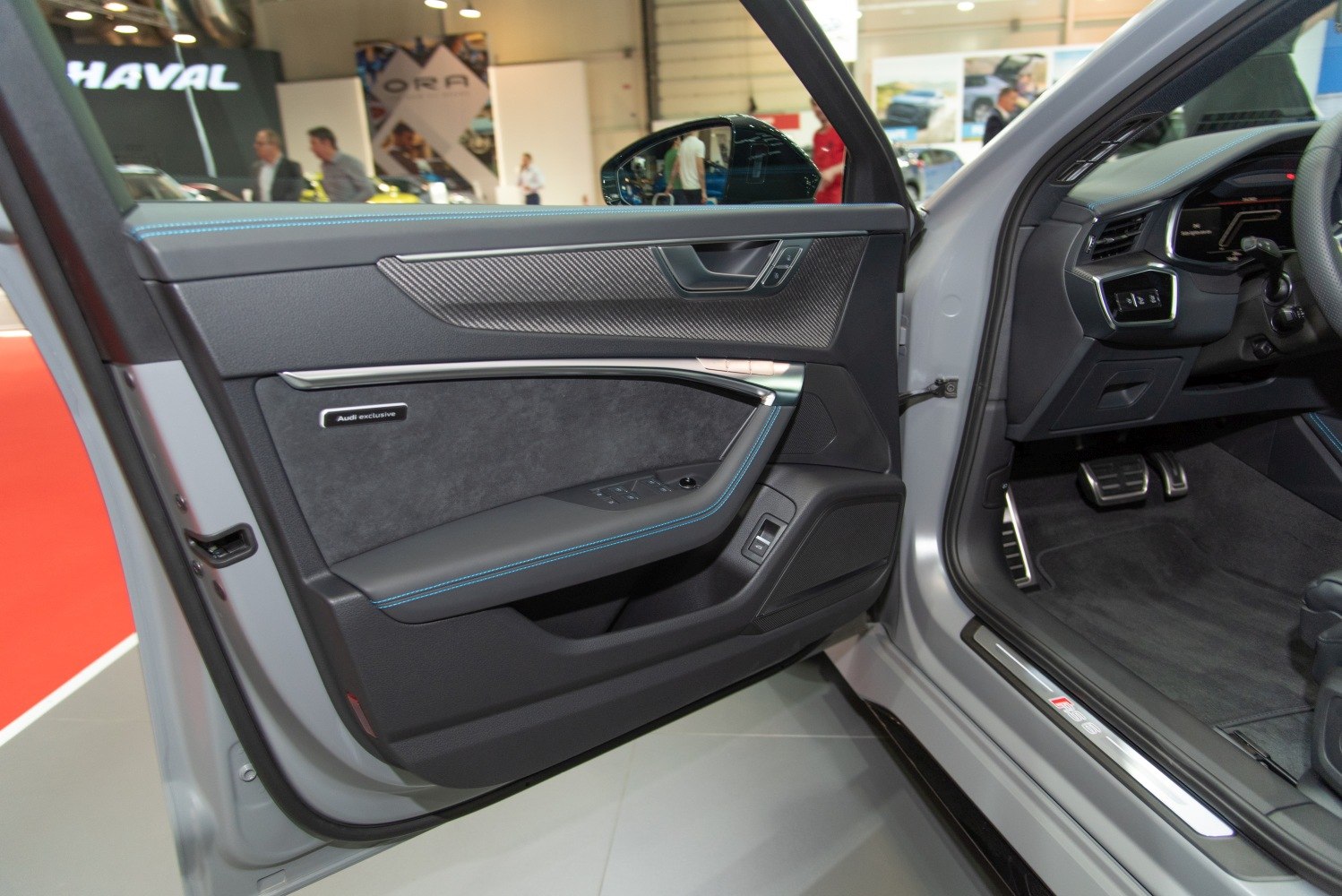 Audi RS 6 Avant interior door panel with carbon fiber and driver footwell.