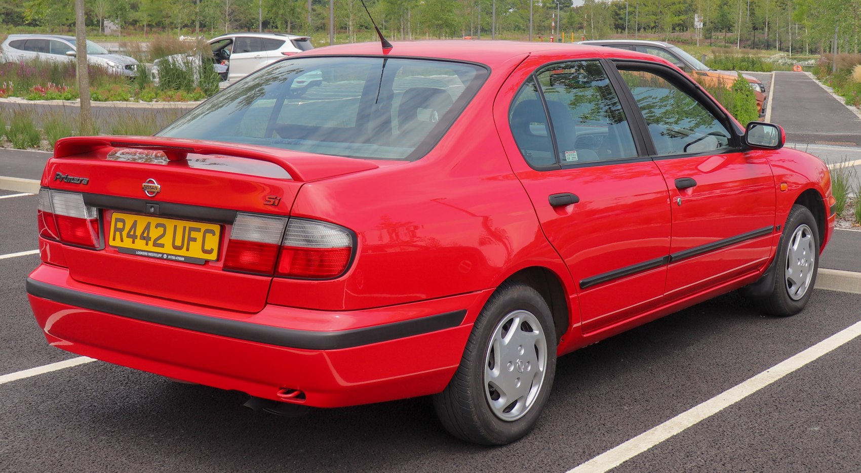 Red sedan with rear spoiler and UK license plate