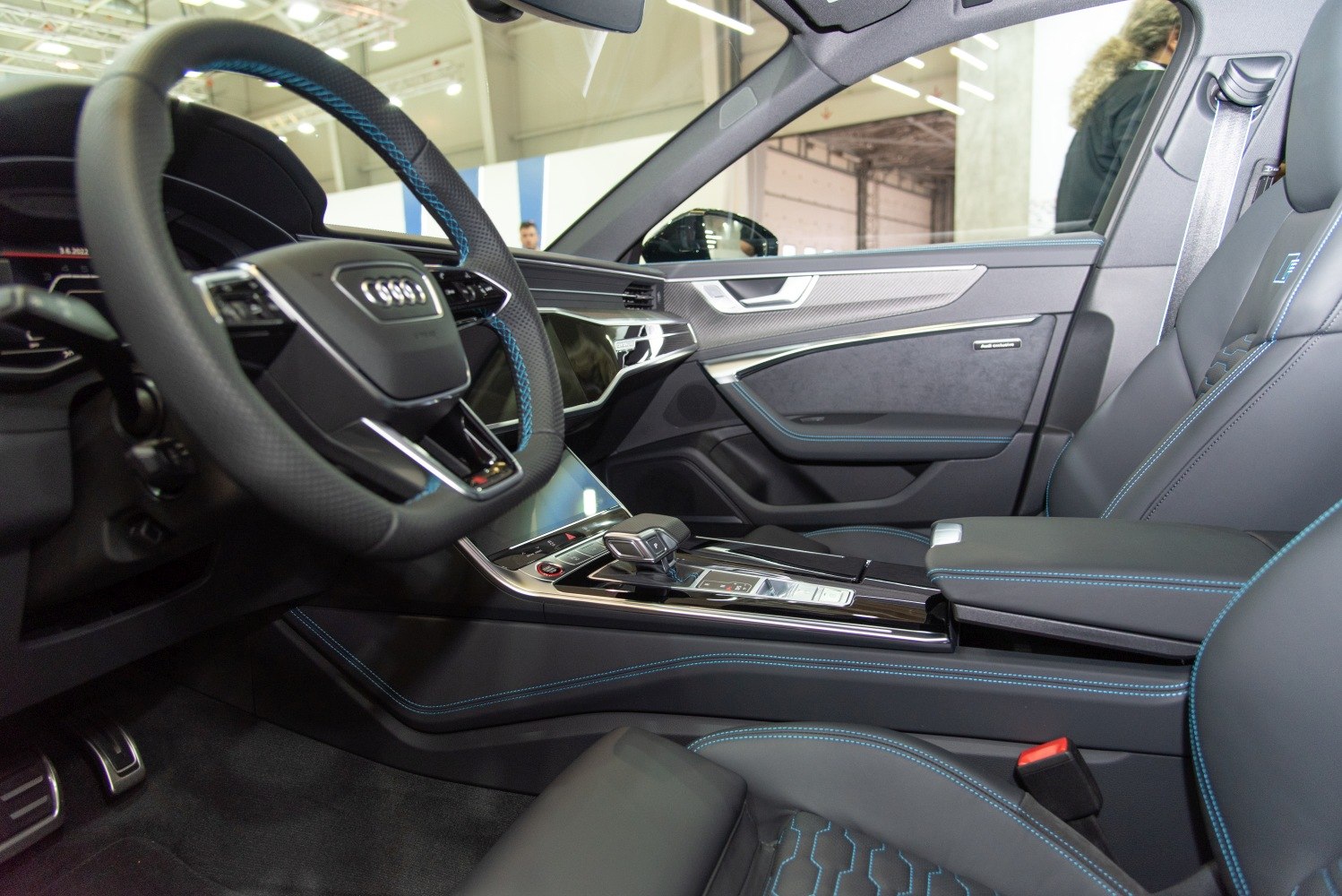 Luxury car interior with digital instruments and blue-stitched leather seats