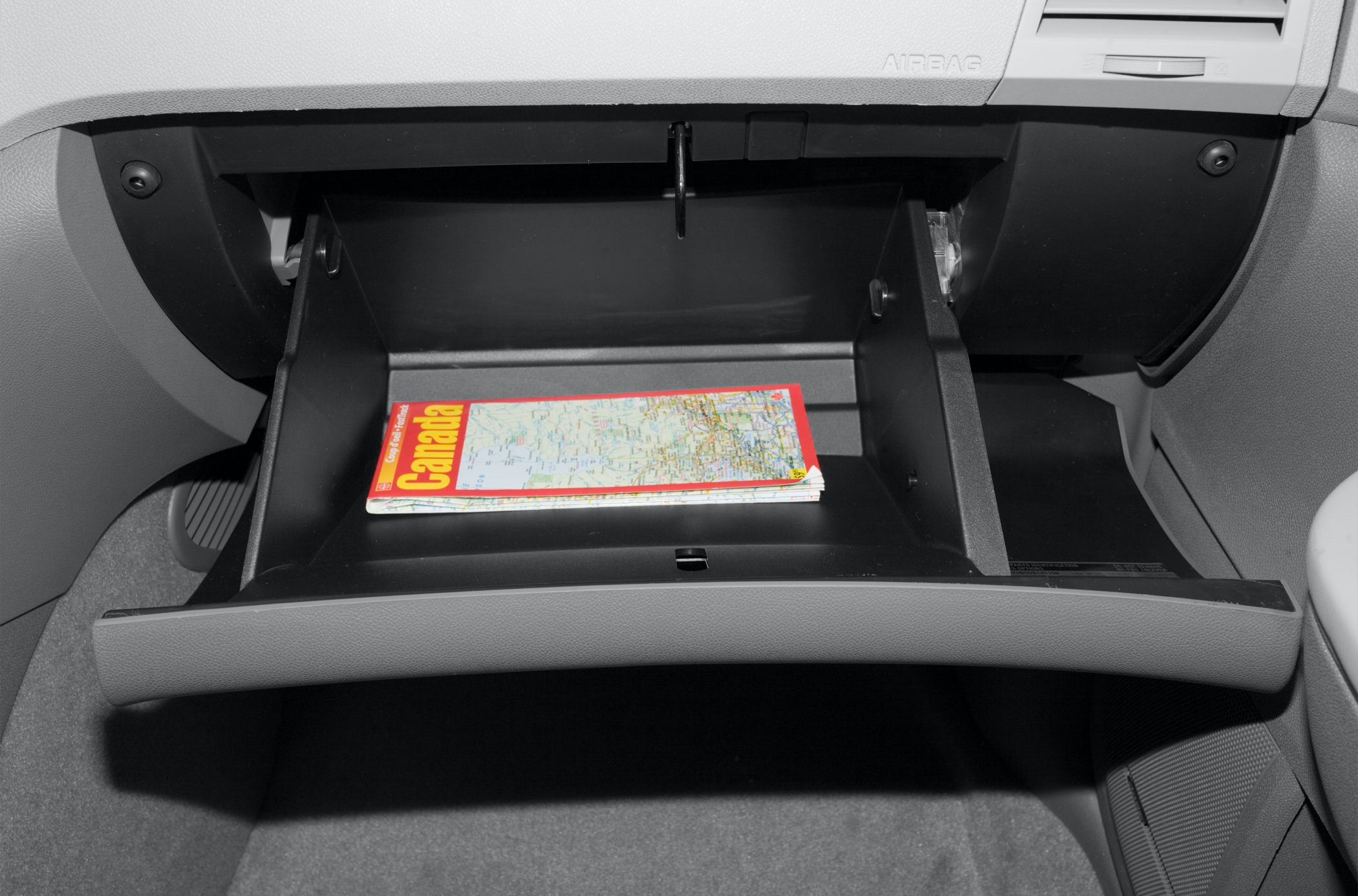 Opened glove compartment with a Canada road map inside