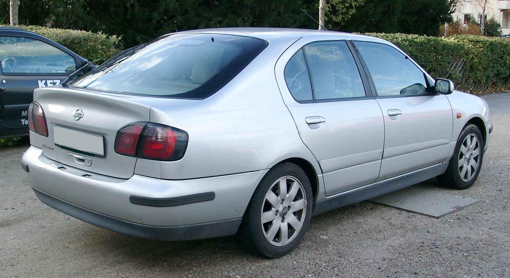 Silver sedan rear and side view with distinct tail lights and alloy wheels