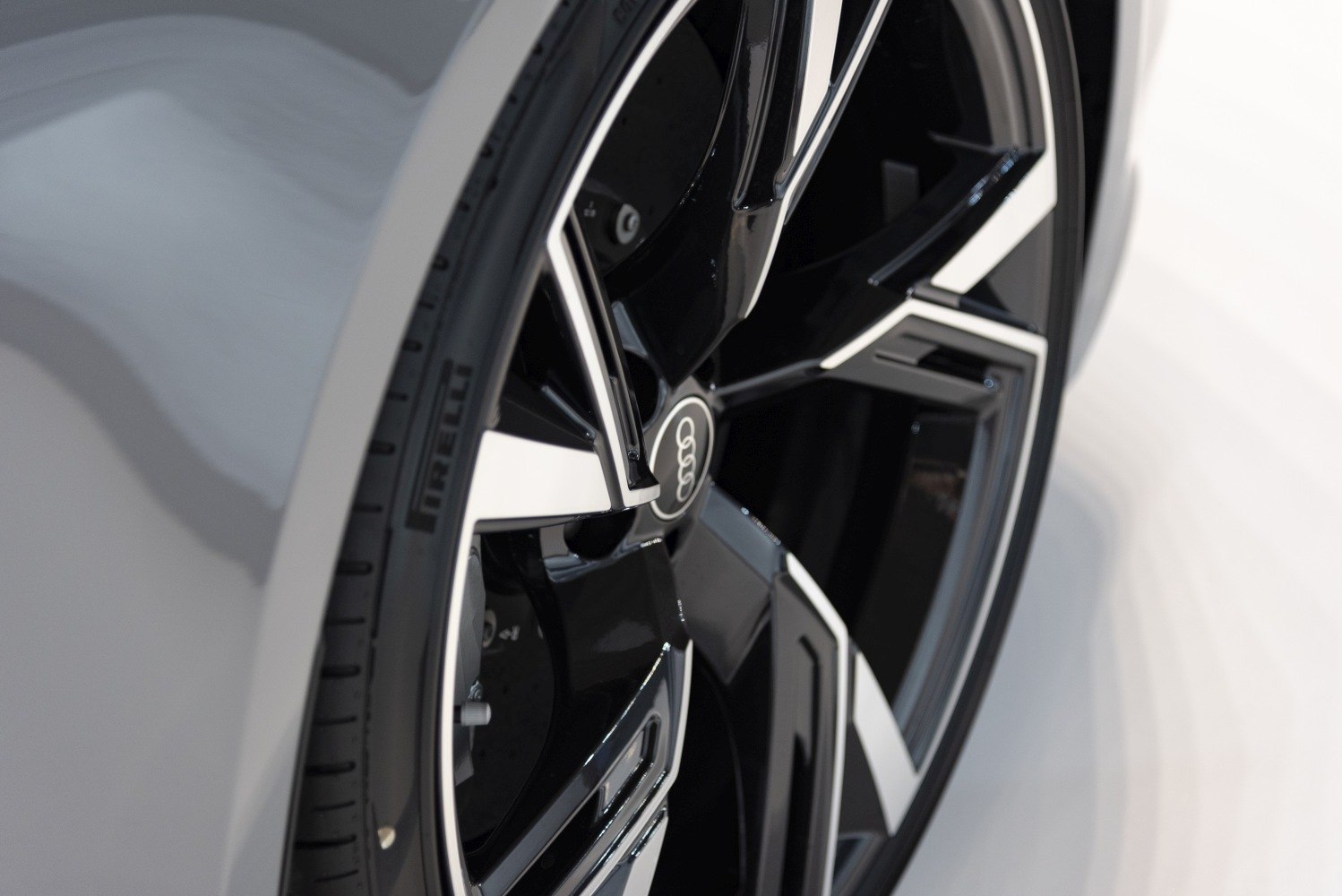 Close-up of black and white multi-spoke alloy wheel with Pirelli tire.