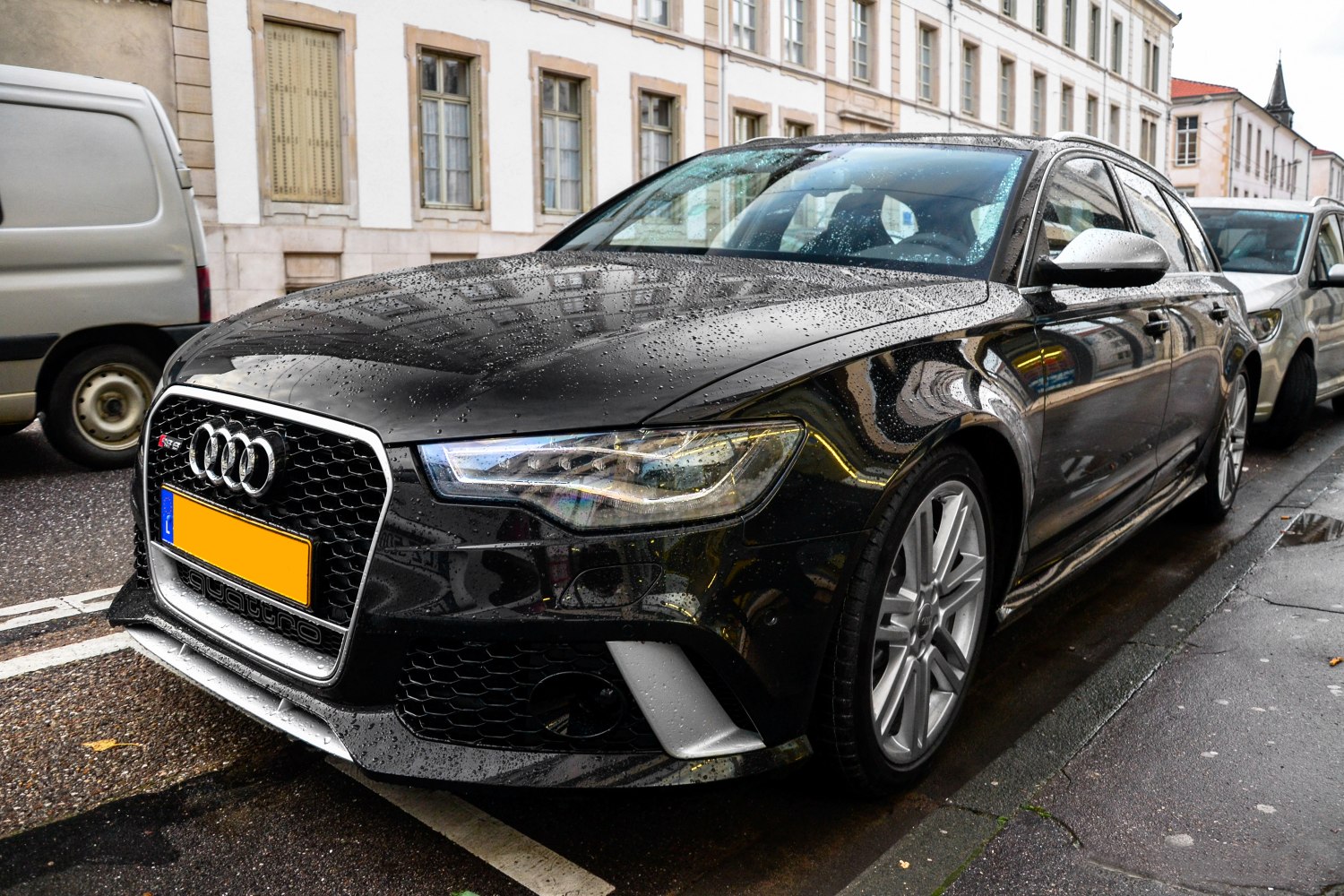 Front grille and headlight close-up of a wet Audi station wagon