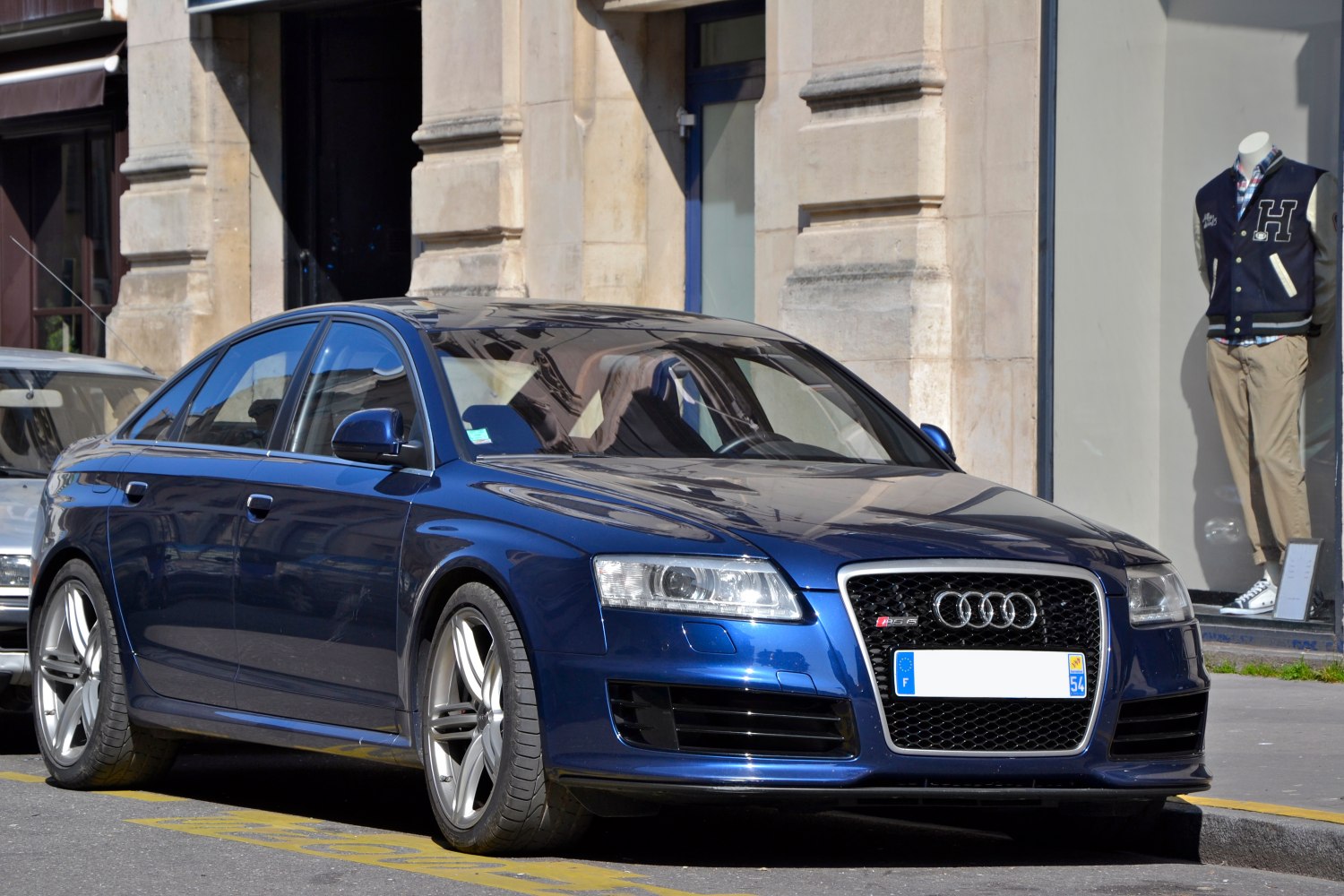 Sporty blue luxury sedan front and side with alloy wheels