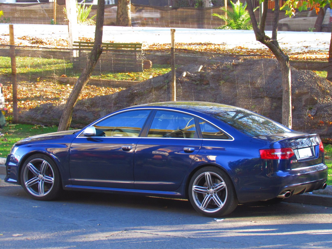 Rear side profile of blue sedan with alloy wheels and sporty design