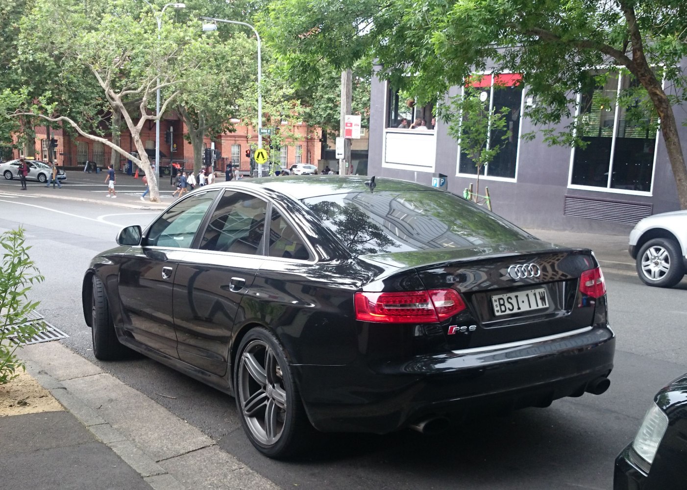 Black sedan rear view with sports wheels and taillights